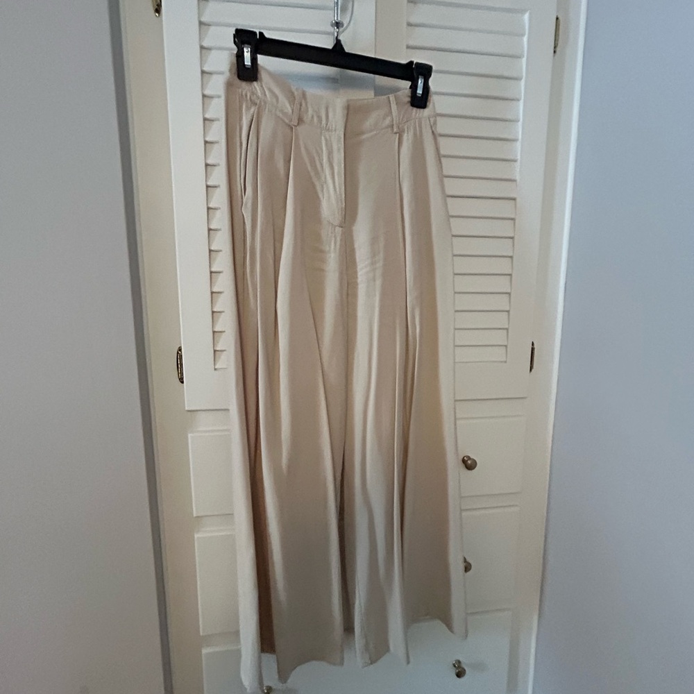 Beige cargo like pants that flare at the bottom
